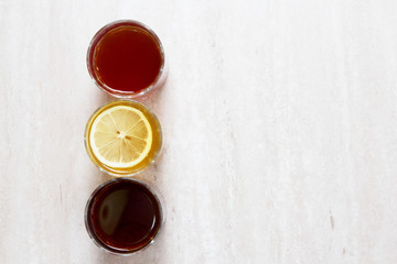 drinks of different colors and texture in glass cups on table on white background. A place for a label. Copyspace