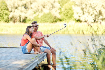 happy teenage couple taking selfie on smartphone