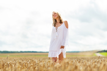 smiling young woman in white dress on cereal field