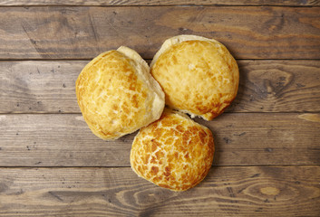 Freshly baked bread rolls on a rustic wooden counter background