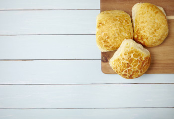 Freshly baked bread rolls on a wooden breakfast table background forming a page border