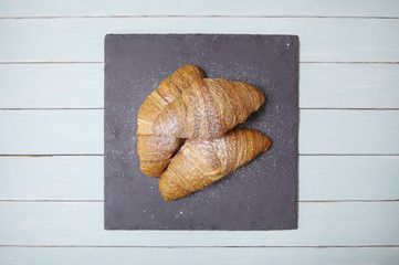Freshly baked croissant pastries on a wooden table top background