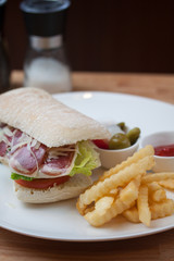 Sandwich with ham, cheese, fresh tomato and green salad