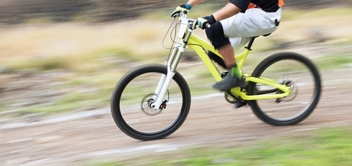 Cyclist riding a mountain bike downhill at high speed