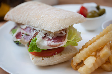 Sandwich with ham, cheese, fresh tomato and green salad