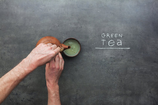 Fototapeta Green tea preparation process on kitchen table with chalky text instructions. Top view on teapot and tea accessories.
