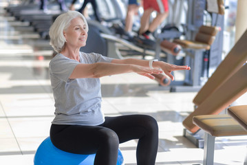 Happy fit smiling woman exercising and using  ball.