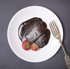 A chocolate fudge cake dessert on a rustic slate background