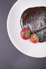 A hot chocolate brownie dessert on a rustic slate tile background