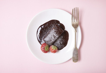 A hot chocolate fudge cake dessert on a pastel pink background