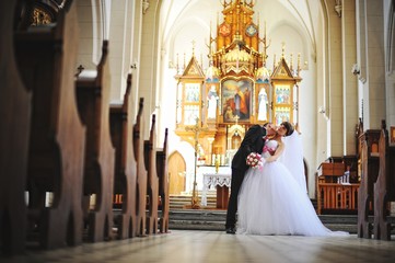 Young beautiful wedding couple at the old catholic church