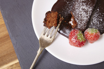 A hot chocolate fudge brownie with fork on a slate background