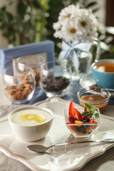 Fototapeta na wymiar semolina porridge for breakfast at a restaurant with nuts and fruit, tea, flowers, healthy food