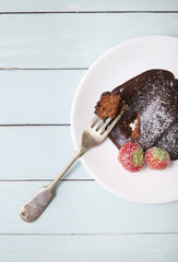 A chocolate fudge cake pudding on a blue wooden table background