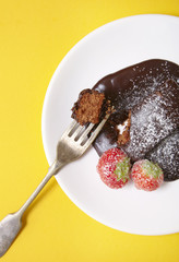 A chocolate fudge brownie pudding on a bright yellow background
