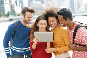 Group of friends in New york city using tablet outside