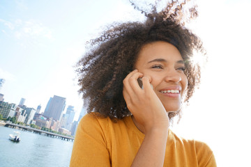 Cheerful mixed raced girl in Manhattan talking on phone