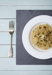 A dinner dish of mushroom and chicken risotto rice on a dining table top background