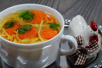 Hot traditional chicken soup in a white dish - energy and warming meal on a cold day