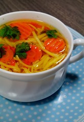 Hot traditional chicken soup in a white dish - energy and warming meal on a cold day
