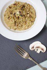 A dinner dish of chicken and mushroom risotto rice on a rustic slate table top background
