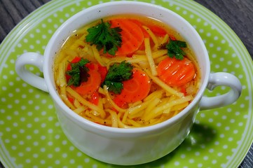 Hot traditional chicken soup in a white dish - energy and warming meal on a cold day