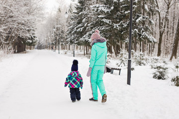Fototapeta na wymiar happy family mother and child baby daughter on a winter walk in the woods