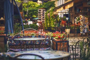 Пустой столик в кафе на красочной улице с цветами