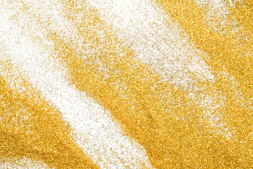 Golden glitter sand texture on white, abstract background.