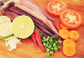 Cooking squids, squids and vegetables on wooden board
