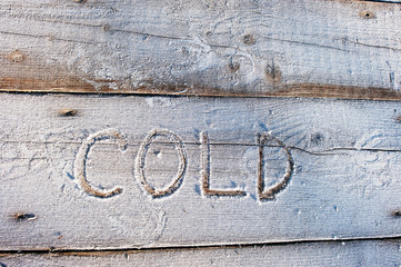Cold written on a wooden background with frosts