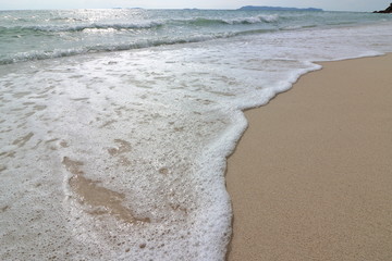 Wave of the sea on the sand beach background, Sea foam