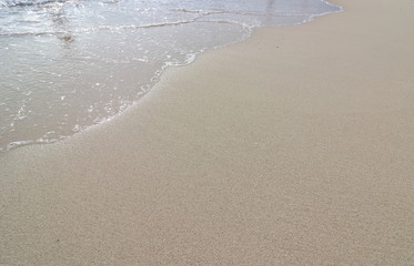 Wave and foam on the sand beach background