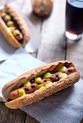 Grilled Hot Dog with cola on wood background