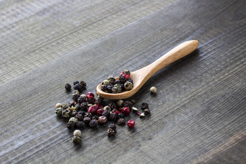 colour pepper with wooden spoon on wooden table