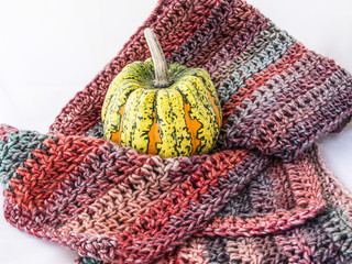 Bufanda de lana y calabaza sobre fondo blanco