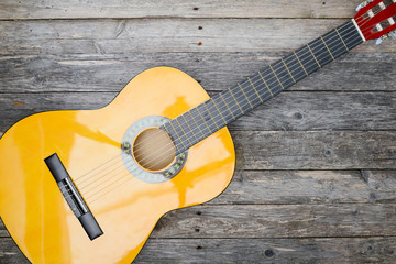 Obraz premium brand new classical guitar on old wooden plank background