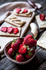 Fruity toast on wooden background. Strawberries, bread, butter and cheese.Vintage style