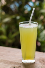 Sugarcane juice with piece of sugarcane on wooden background