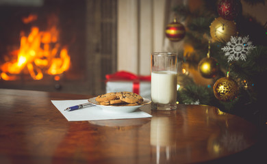 Closeup of wish list and treats for Santa Claus on table next to