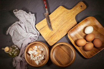 Fototapeta na wymiar Ingredients for preparation of home-made cabbage pie. Boiled eggs, flour, cabbage, olive oil on a kitchen table. Food composition on a dark background. Vintage toning