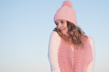 Emotive portrait of a fashionable model in white standing at the winter field. Sunny weather. Outdoor shot.