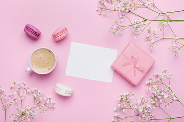 Fototapeta na wymiar Morning cup of coffee, cake macaron, gift or present box and flower on pink table from above. Beautiful breakfast. Flat lay style.