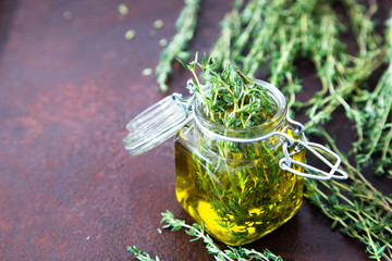 Thyme oil. Thyme essential oil jar glass bottle and branches of