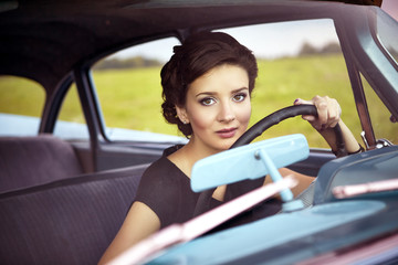 Beautiful lady sitting in a retro car