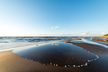 comfortable beach of the baltic sea with rocks and green vegetat