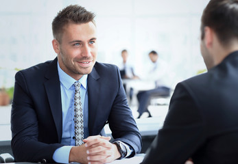 Image of smart businessman explaining new strategy to his partner at meeting