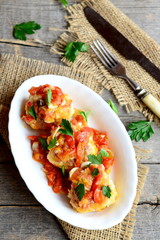 Delicious meatballs with vegetable sauce, fork, knife on old wooden table. Meatballs braised with tomato, onion, carrot, sweet pepper. Traditional meat dish. Rustic style. Top view