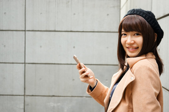 Young attractive woman using her smartphone 