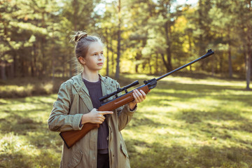 Girl shooting from the air rifle in the forest
